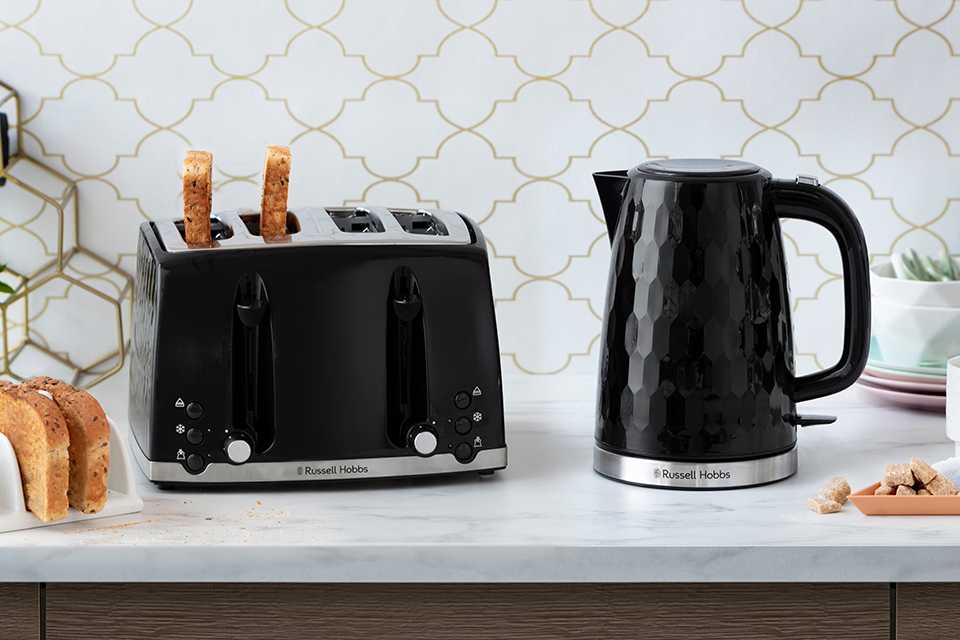 Russell Hobbs kettle and two slice toaster in black placed on a marble kitchentop.