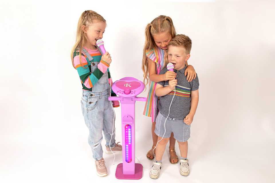 A group of friends singing their favourite song using a toy karaoke set.