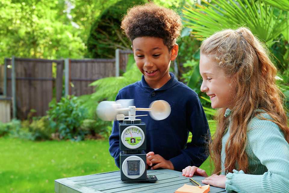 Two kids playing with Science Mad 5 in 1 Weather Station STEM toys.
