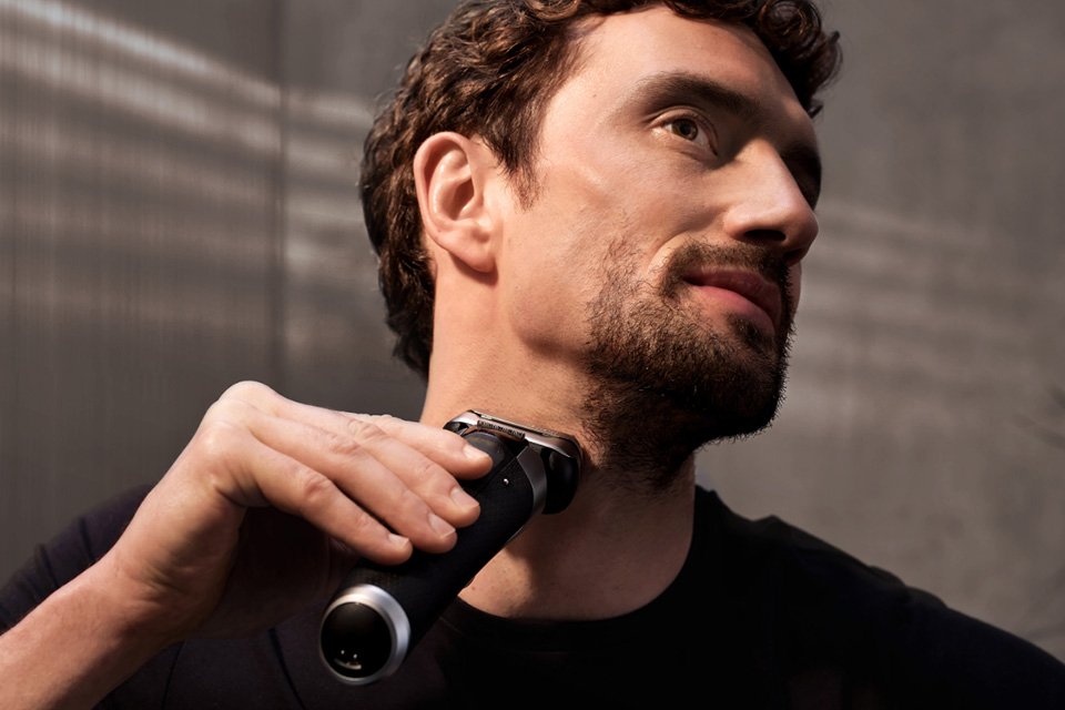 A man using Braun Series 9 Pro+ shaver against his beard.