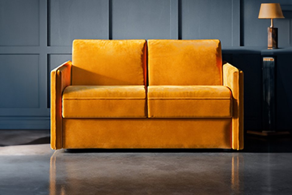 An orange Jay-Be® Slim sofa bed in a living room setup.