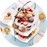 An afternoon tea table laid out with many food items and drinks.