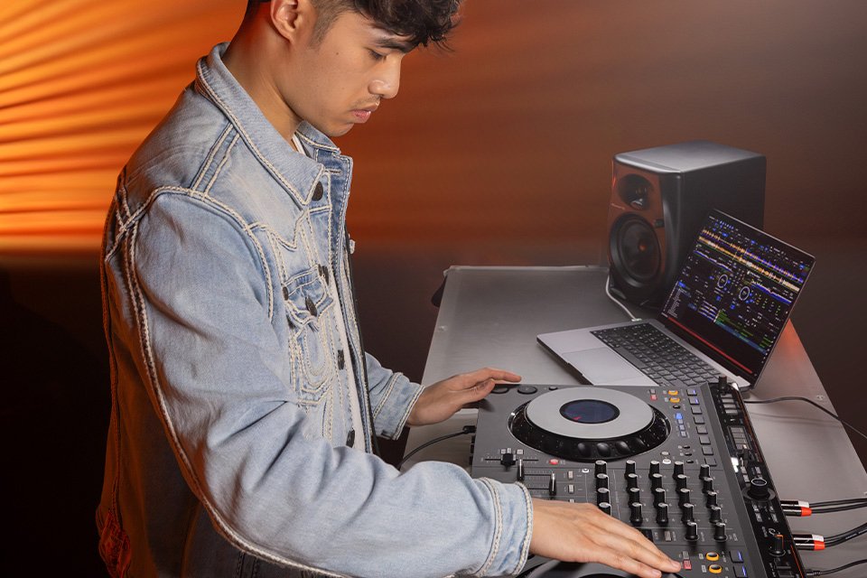 A young man using a Pioneer DJ controller.