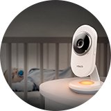A baby monitor on a table in a nursery where baby is sleeping.