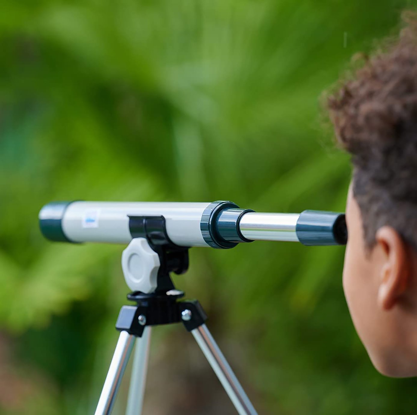 a boy looking through a telescope