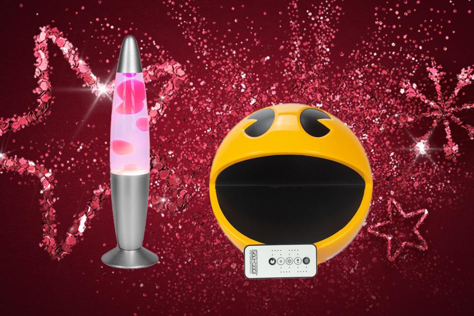 A pink lava lamp and a novelty Pacman light in front of a pink glittery background.