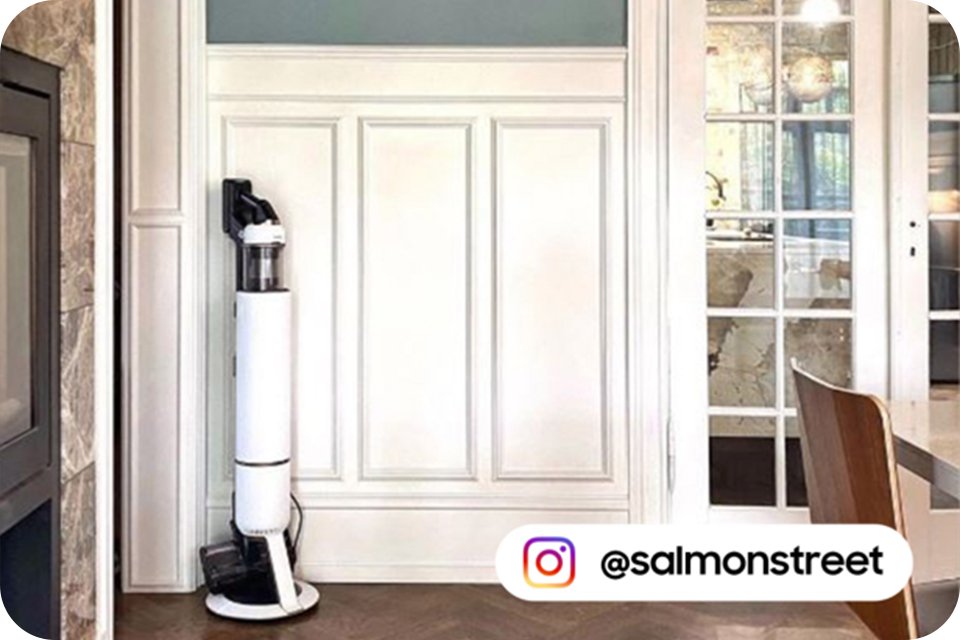 A shot of a white Samsung vacuum cleaner placed next to a wall with Instagram ID @salmonstreet written on the picture.