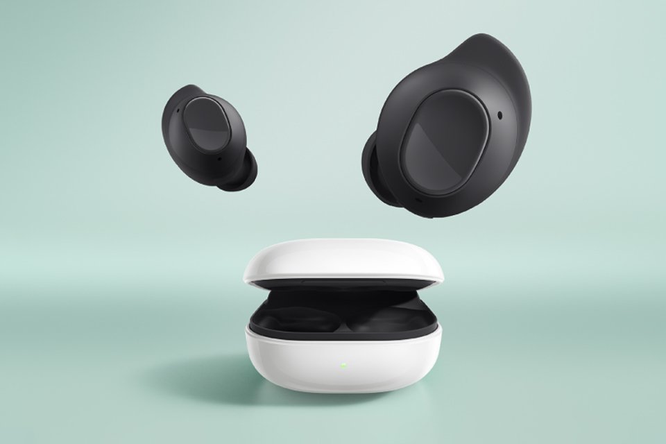 Samsung Galaxy Buds FE earbuds floating out of its charging case on mint green background.