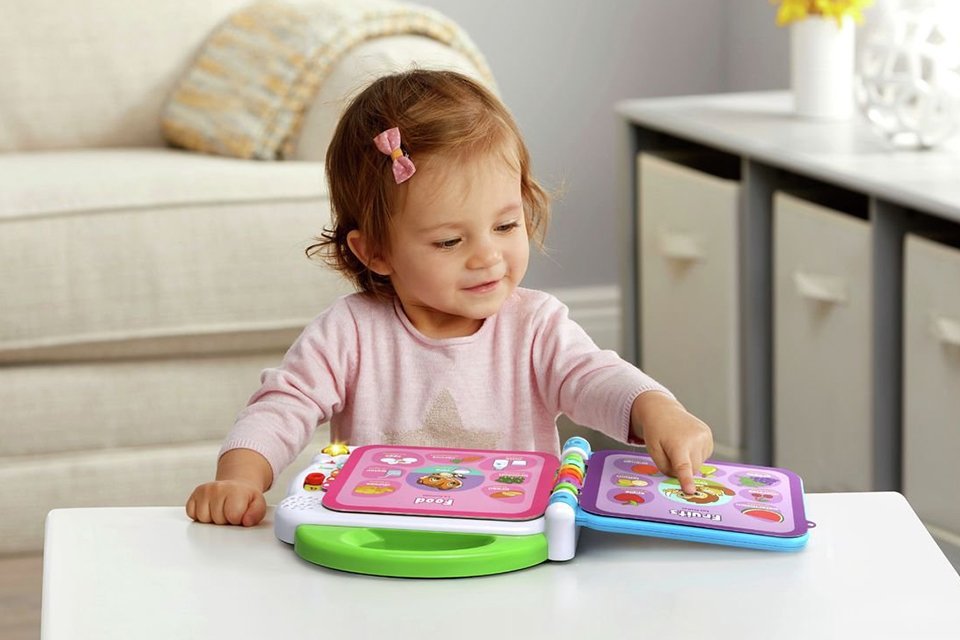 A child playing with a LeapFrog Learning Friends 100 words book.