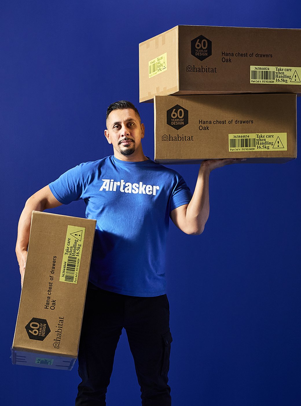 Air tasker man holding cardboard delivery boxes ready to unbox and build a flat pack.