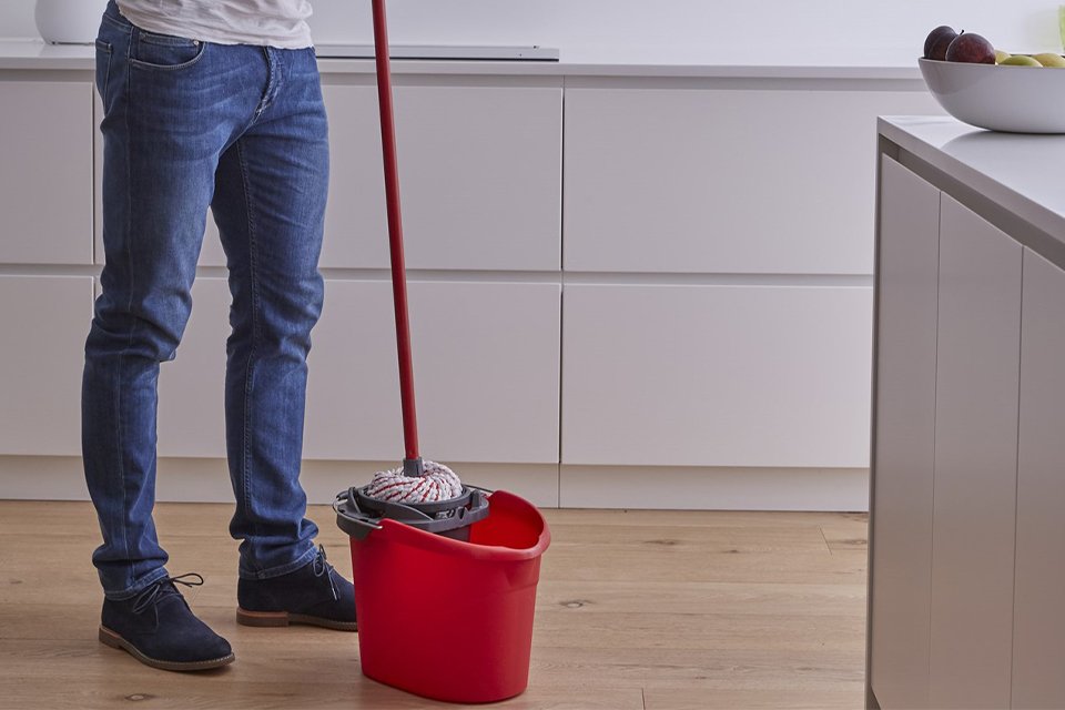 A man using a Vileda 10 Litre Microfibre Power Mop and Bucket Set.