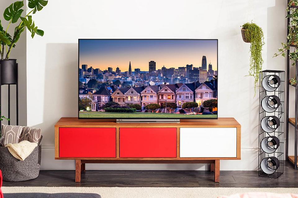 Toshiba Alexa TV on wooden TV stand.