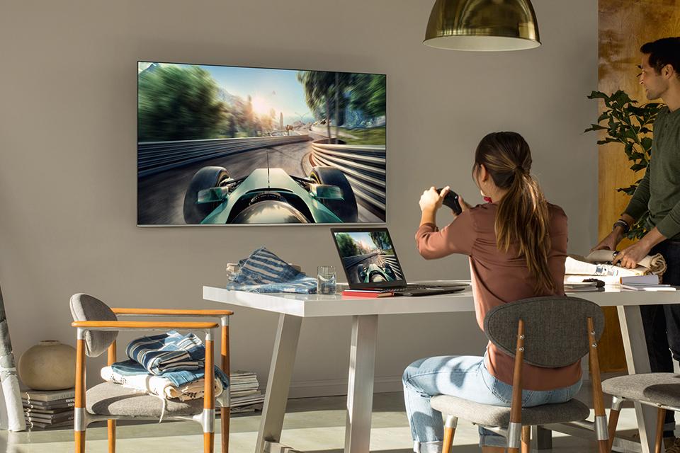 Woman playing a racing game on a smart TV.