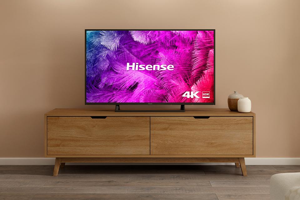 4K Hisense TV on wooden TV stand.