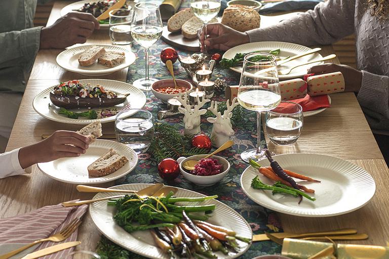 Image of a dining table dressed in festive dinnerware and Christmas Day dinner.