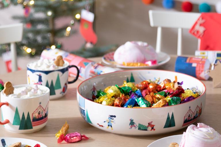 Image of a festive bowl and mugs filled with hot chocolate and sweets.