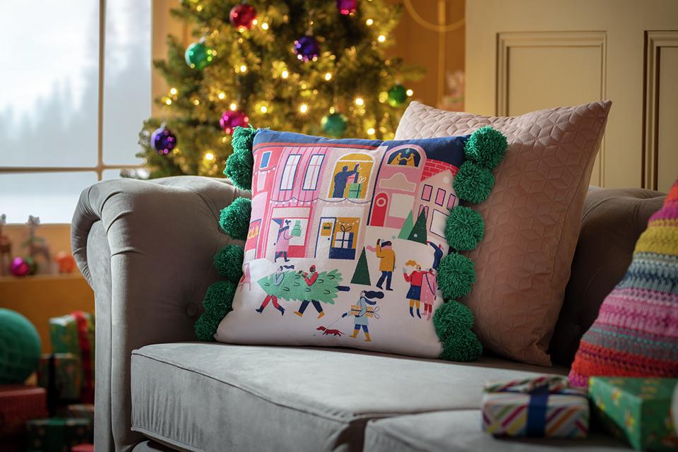 Image of a cushion ith a festive pattern on a sofa.
