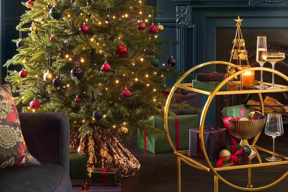 Image of a gold drinks trolley by a christmas tree.