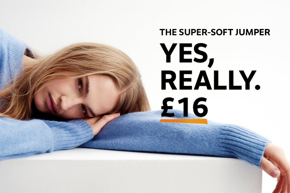 Woman wearing light blue jumper with a white shirt underneath.