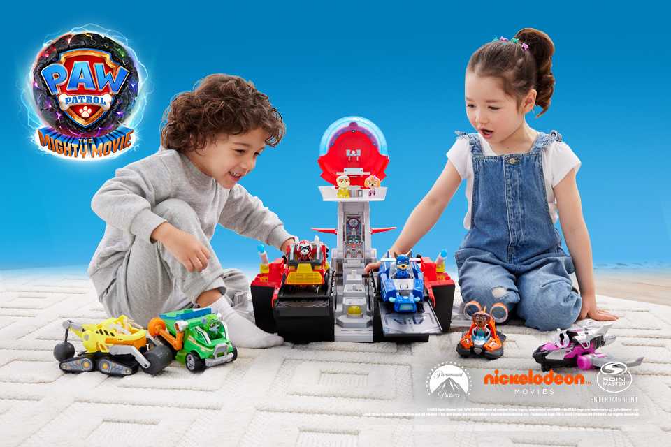 Two kids playing with PAW Patrol Mighty Movie merchandise.