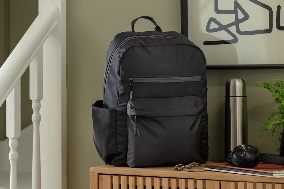 Argos Home Block Colour Grey Backpack placed on a wooden storage unit. 