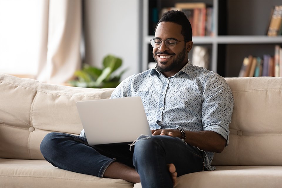 A man working on his laptop from the living room.