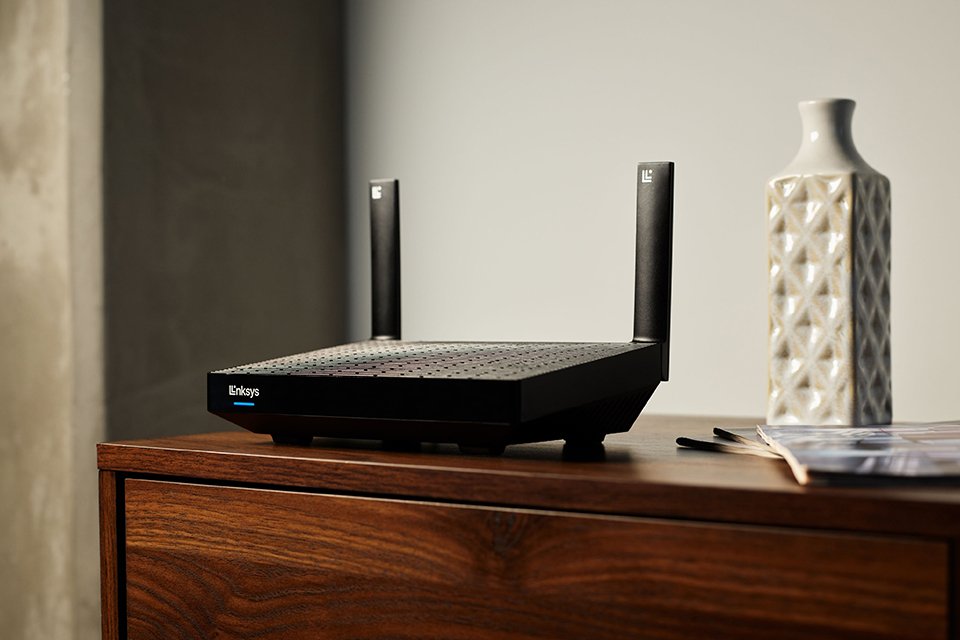 A black dual band router on the coffee table in an apartment.