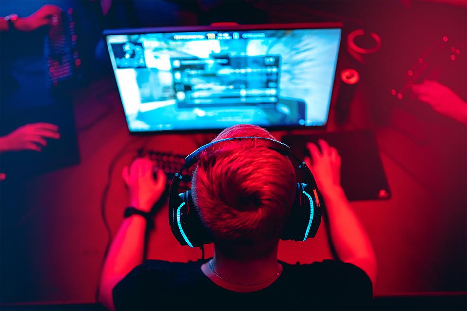 A young man plays on his gaming PC.