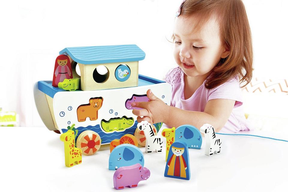 Girl playing with wooden shape sorter.