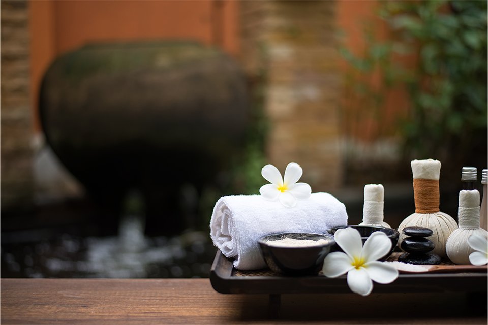 A relaxing spa scene with soft towels, flowers.