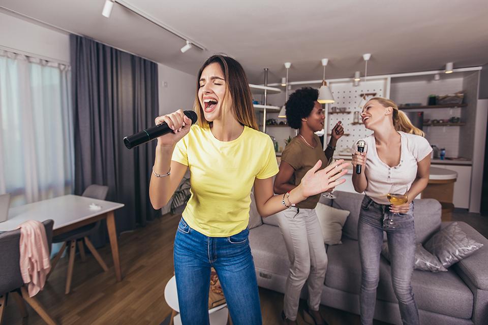 A group of woman sing karaoke together.