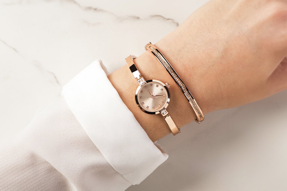 A woman wearing a Spirit stone watch and bracelet in rose colour.