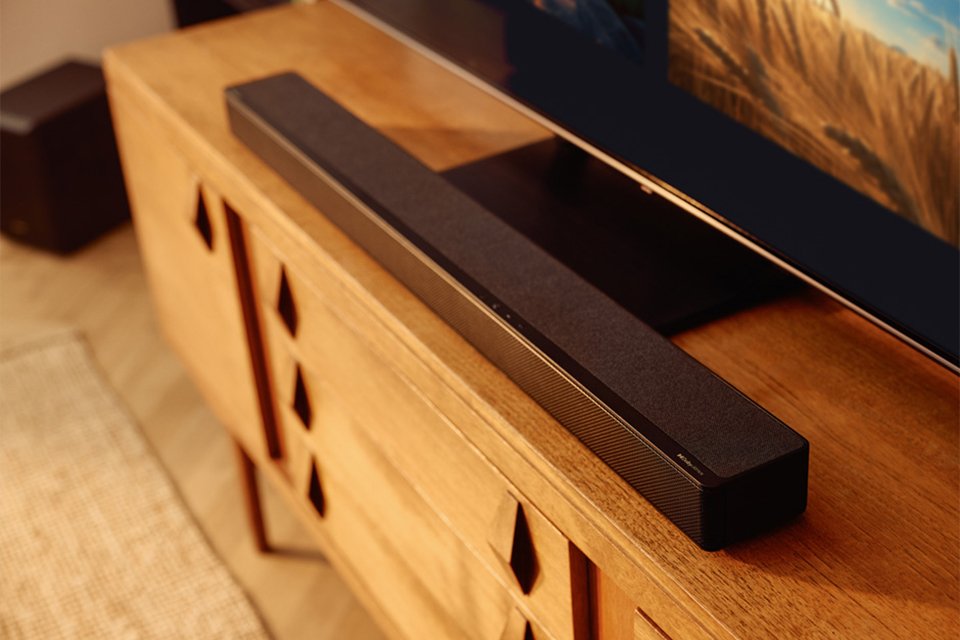 A Hisense soundbar placed under a TV on a cabinet.