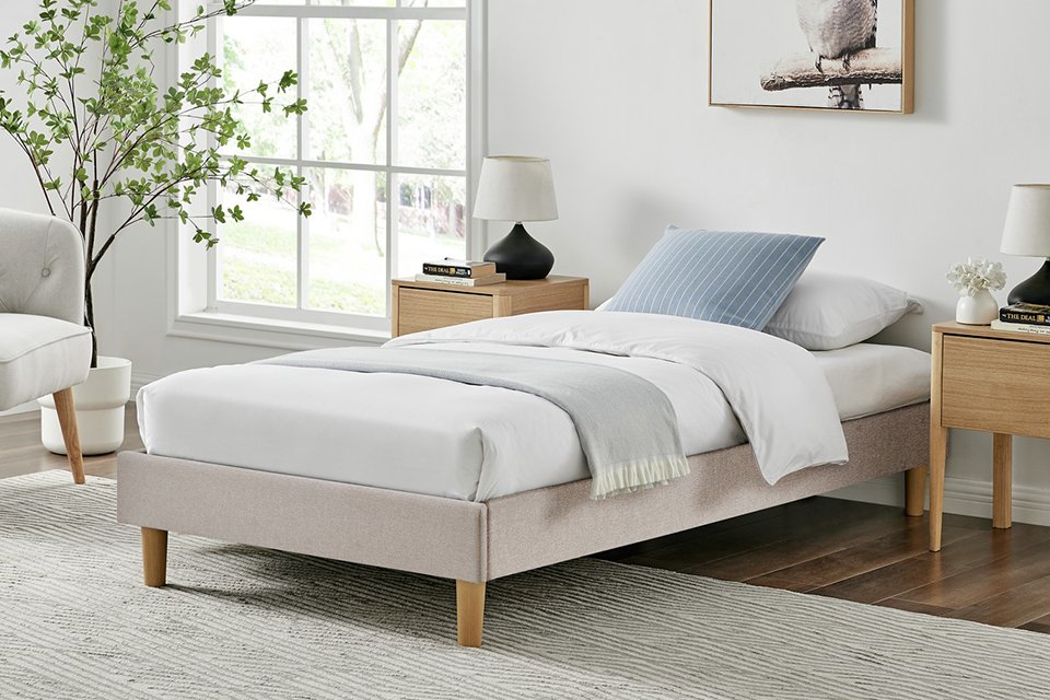 A white mattress on an Argos Home Arthur single bed frame near a bedside table.