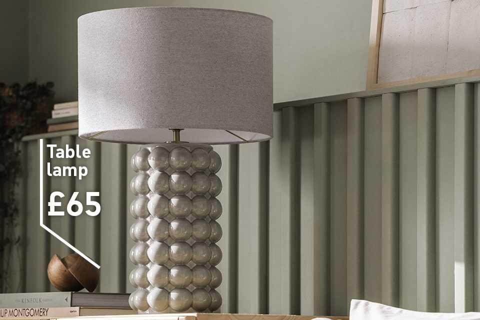 Grey bobble table lamp on a bedside table.