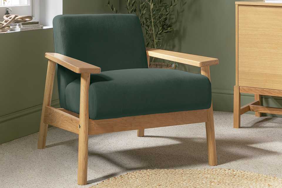 A wooden armchair with green upholstery.