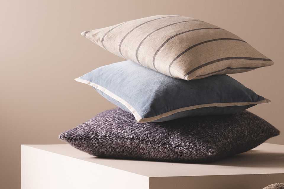 3 pillows stacked on top of the other in front of a natural background.