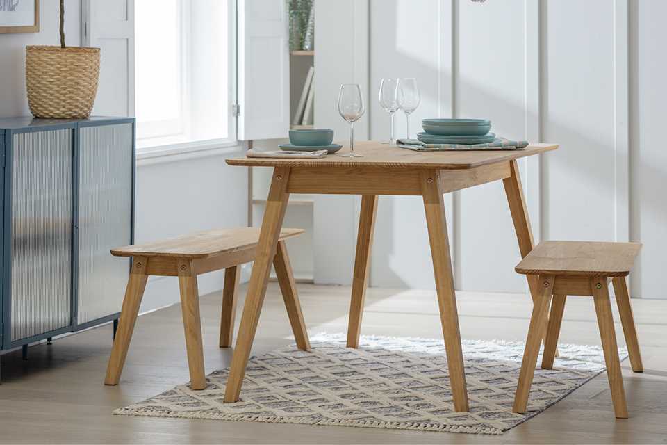 A wooden dining table and benches in a dining room.