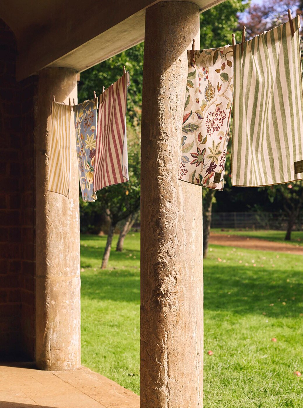 Habitat x National Trust collaboration tea towels hung up outisde national trust huse. Striped and floral print tea towels.