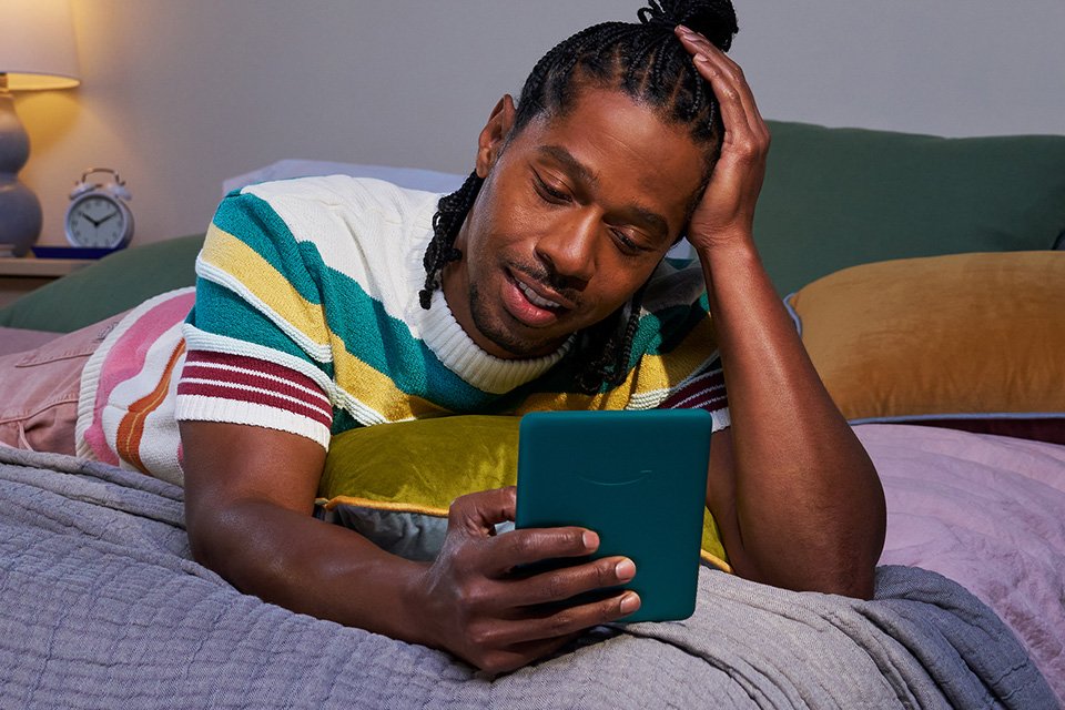 A man reading on an Amazon Kindle Paperwhite 2024 7In 16GB Wi-Fi E-Reader.