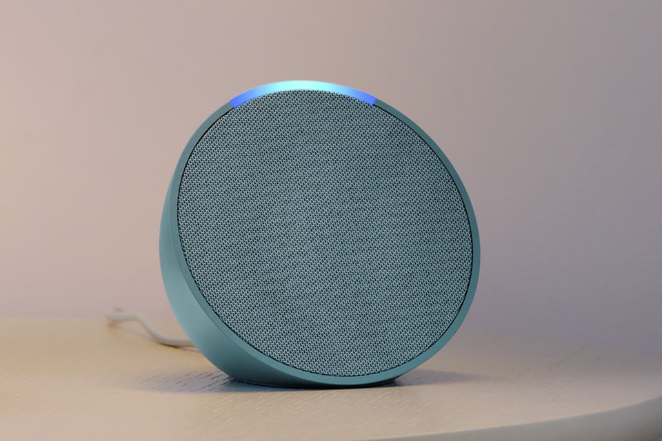 An Amazon Echo Pop 2023 Smart Speaker with Alexa on a side table.