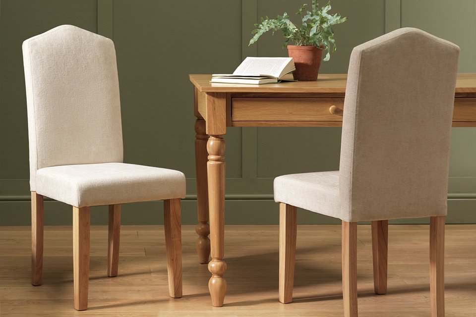 Two wooden chairs near a rectangular dining table.
