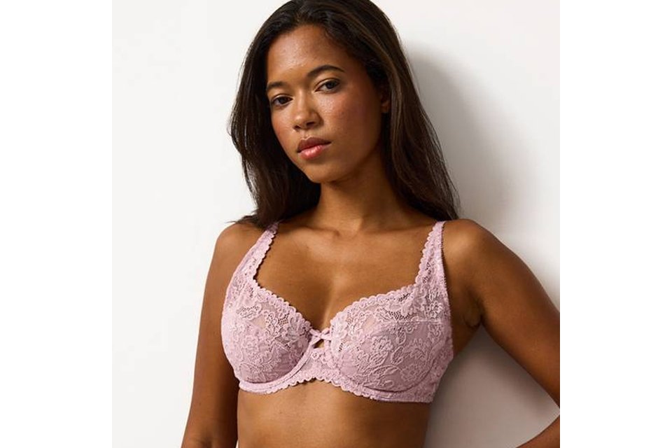 A woman wearing a pink full cup lace bra.