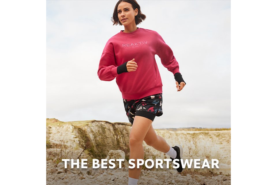 A woman wearing a pink reaktiv jumper and shorts, running outside.