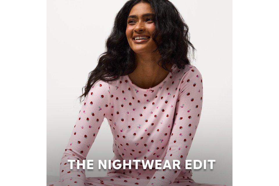Person wearing pink nightwear top with a subtle heart pattern from the nightwear edit. 