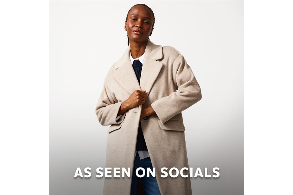 Model wearing a neutral long coat styled for social media fashion trends. 