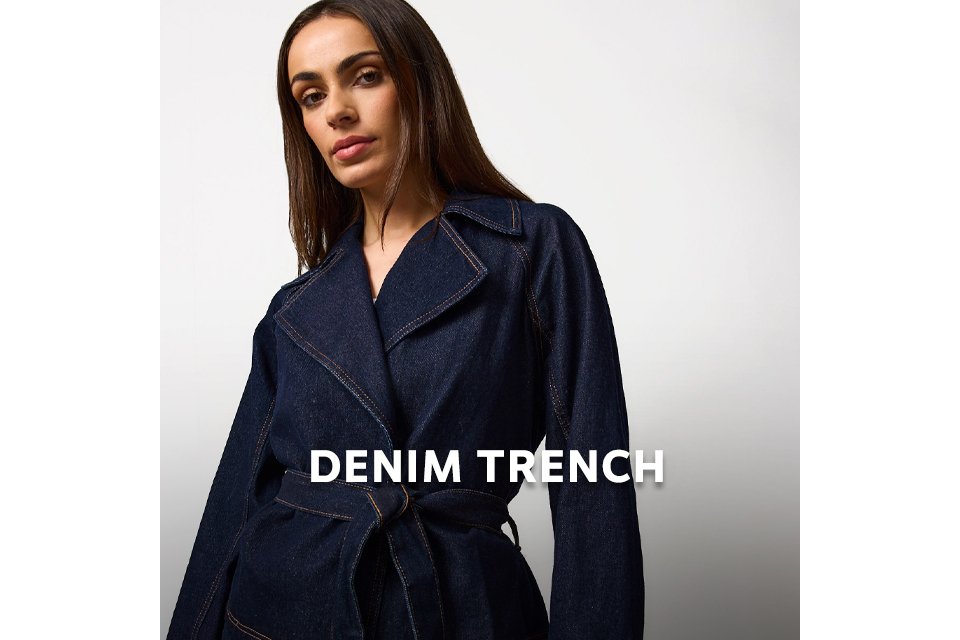 Person wearing a dark denim trench coat with contrast stitching.