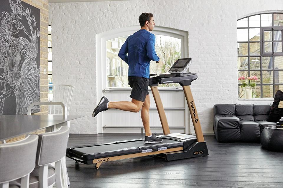 A woman running inside on a treadmill.