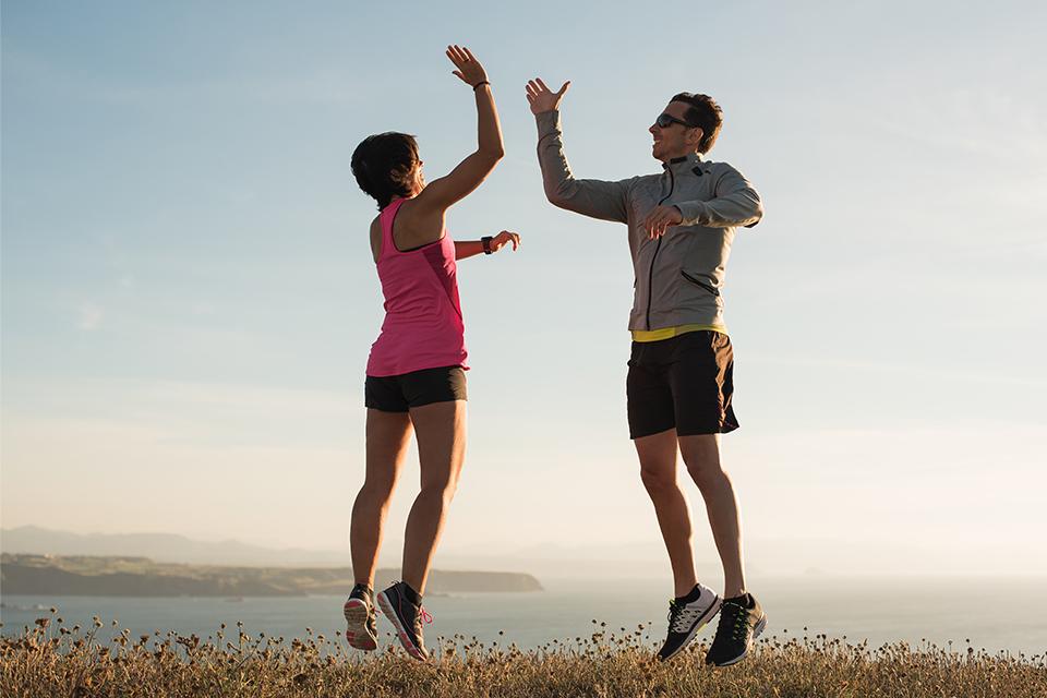 A man and woman high fiving to celebrate the end of a run.
