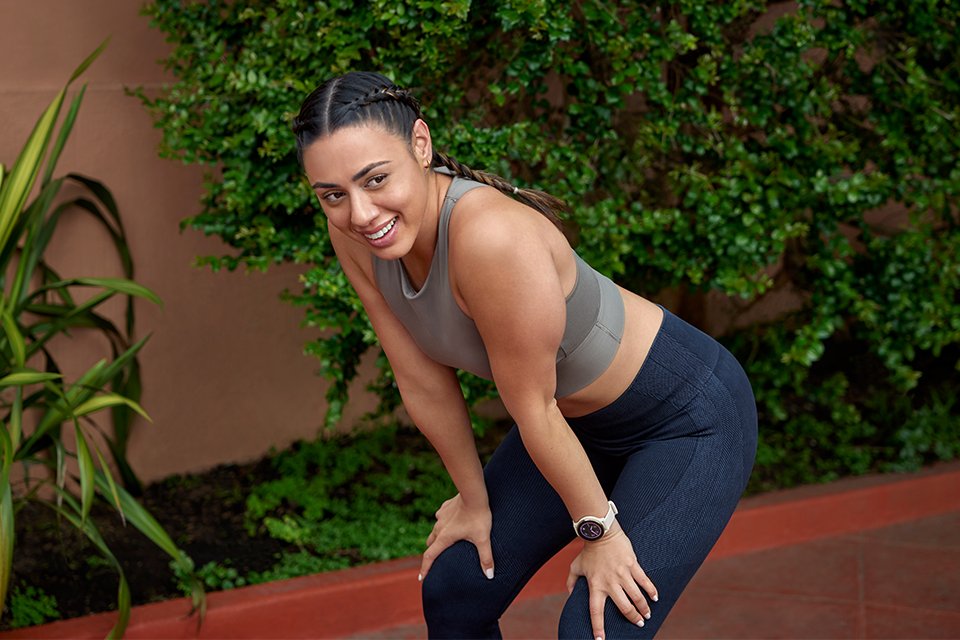 A woman wearing Garmin Venu series of health and fitness smartwatches while training. 